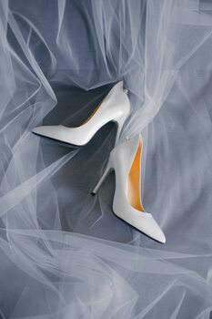 Art Photography Bride's shoes with a veil top view close-up