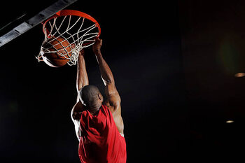 Valokuvataide Man dunking basketball