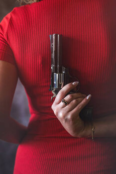 Art Photography young woman in red dress holding gun pistol