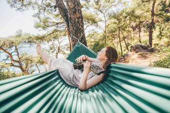 Canvas Print Woman relaxing in hammock and playing