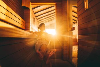 Poster A young woman relaxing in an eco wooden sauna
