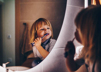 Poster sweet young boy is brushing teeth