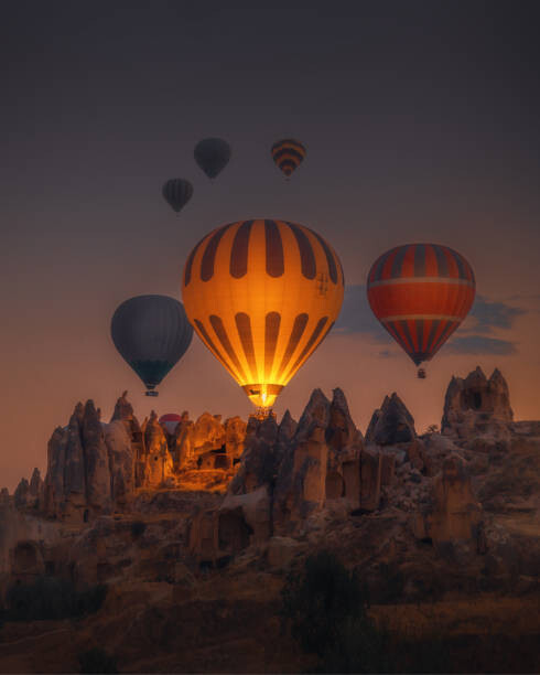 Art Photography Hot Air balloons flying over rock