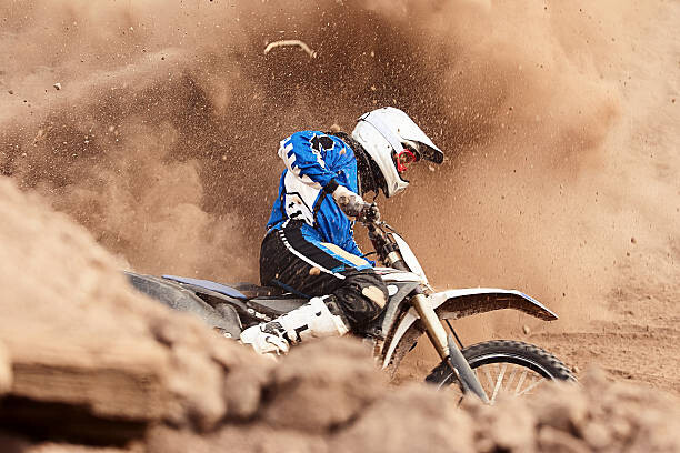 Valokuvataide Motocross biker taking a turn in the dirt.