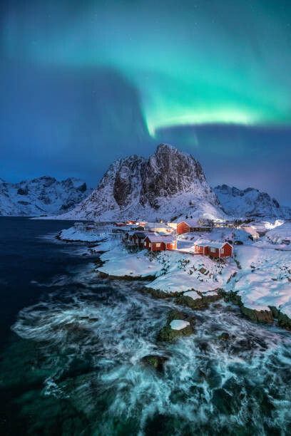 Art Photography Northern lights over snowcapped mountain, village