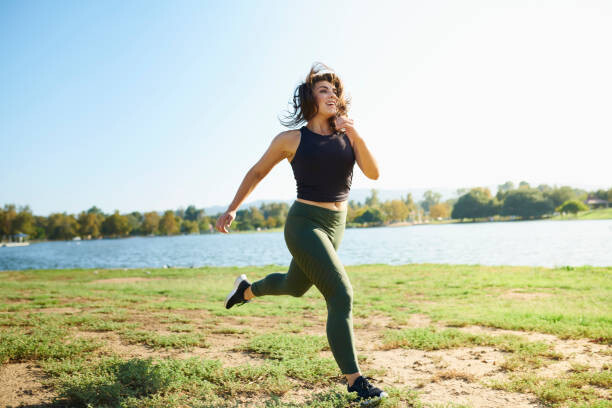 Art Photography Smiling young woman jogging near lake on sunny day