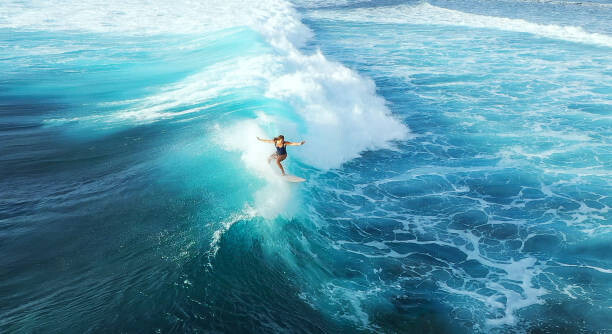 Arte Fotográfica Surfer woman riding on the blue ocean