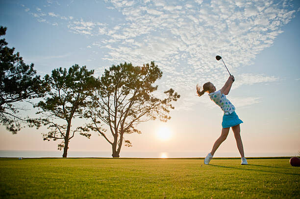 Art Photography Teen girl makes a powerful drive on a golf course