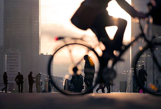 Canvas Print Businessman on bicycle passing skyline La Defense