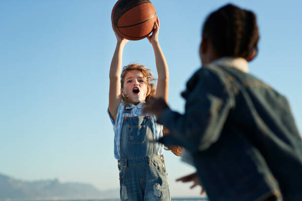 Canvas Print Children together playing on beach by the ocean