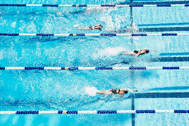 Canvas Print Competitive swimmers racing in outdoor pool