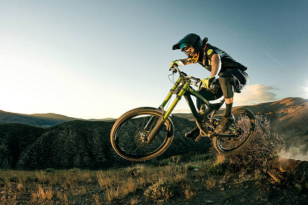 Canvas Print Female biker jumping on her mountain bike.