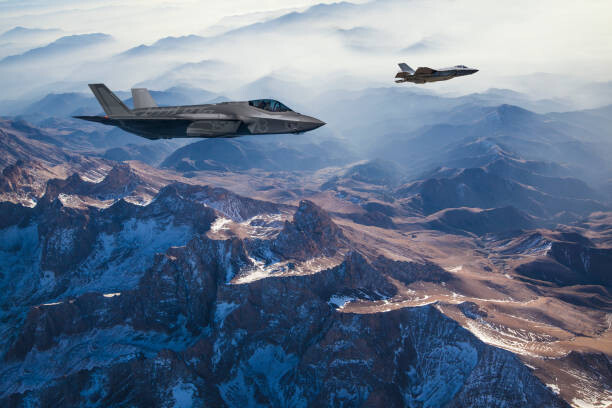 Canvas Print Fighter Jets flying over mountains at dusk