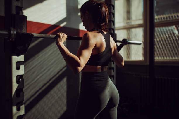 Canvas Print Fit young woman training alone in dark gym