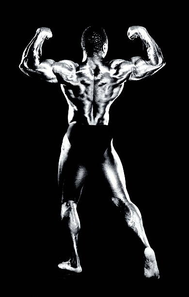Canvas Print Male bodybuilder flexing muscles, rear view (B&W)