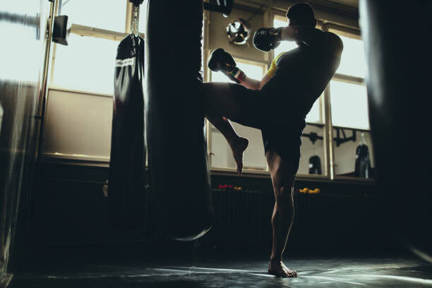 Canvas Print Man kick boxer training alone in gym