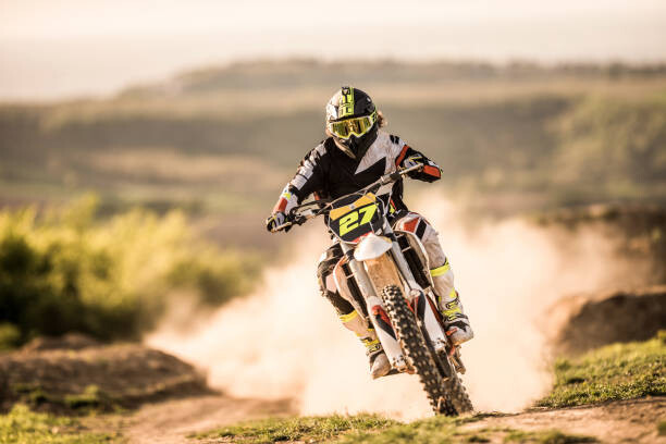 Canvas Print Man on dirt bike racing on dirt road in nature.