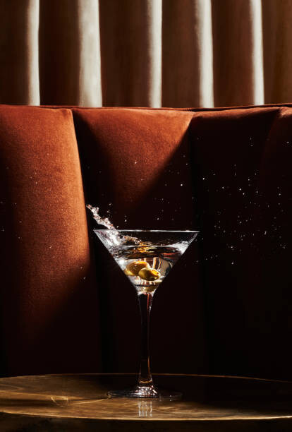 Canvas Print Martini glass with splashing olives in