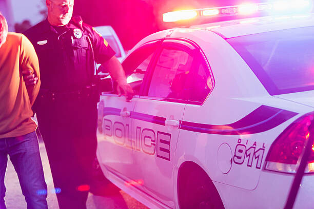 Canvas Print Police officer arresting a young man at night