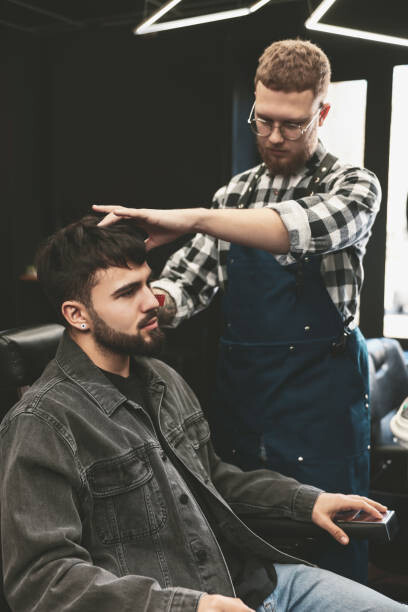 Canvas Print Professional hairdresser working with bearded client
