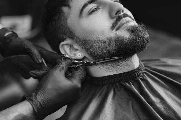 Canvas Print Professional hairdresser working with bearded client