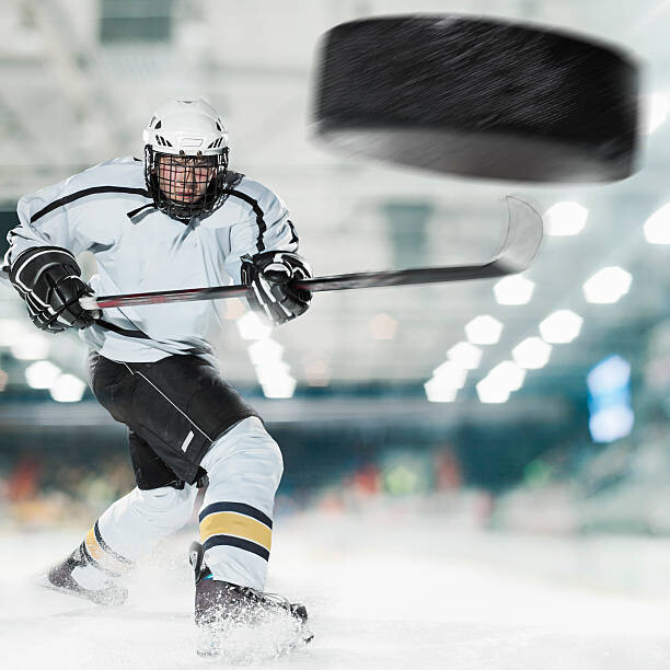 Canvas Print Puck shot by Ice hockey player
