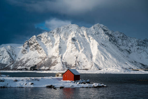 Canvas Print Red cabin in a fjord in winter