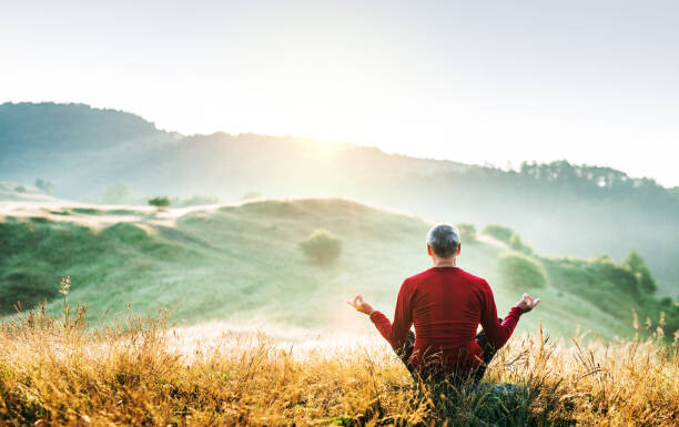 Canvas Print Senior man meditating outdoors in nature