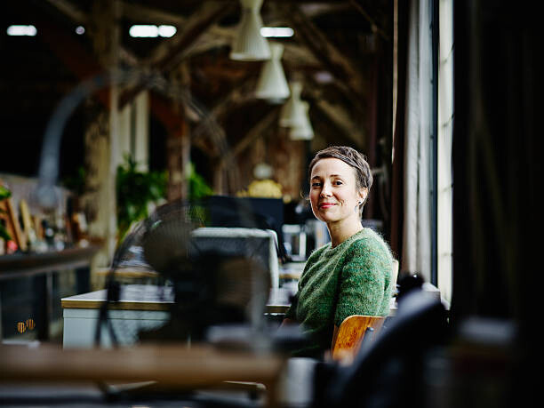 Canvas Print Smiling businesswoman sitting at workstation