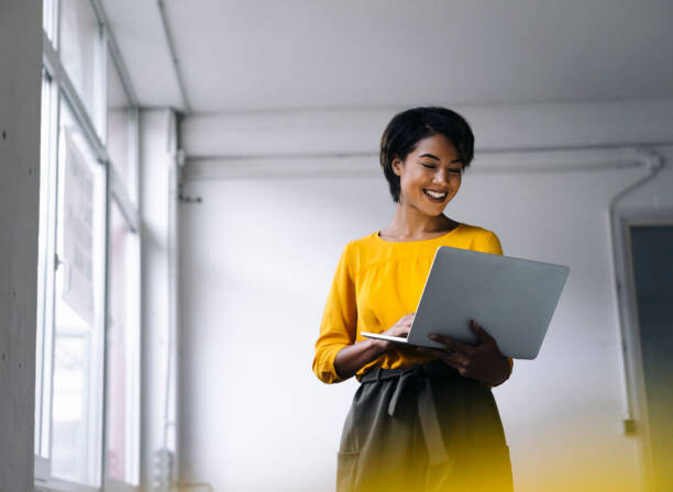 Canvas Print Smiling woman using laptop