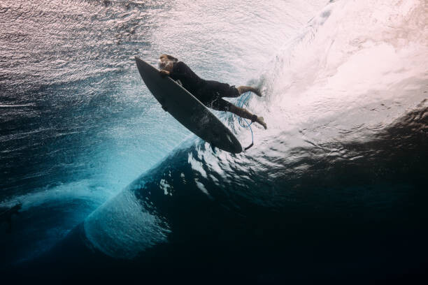 Canvas Print Surfer dives beneath a wave