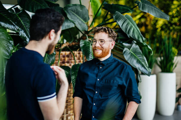 Canvas Print Two Colleagues Standing Amongst Potted Plants