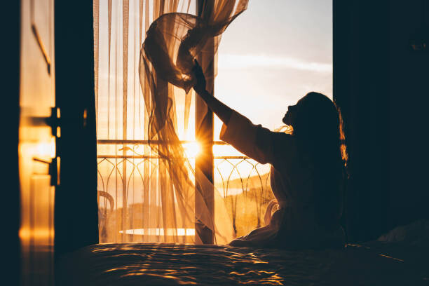 Canvas Print Woman opens curtain to enjoy view