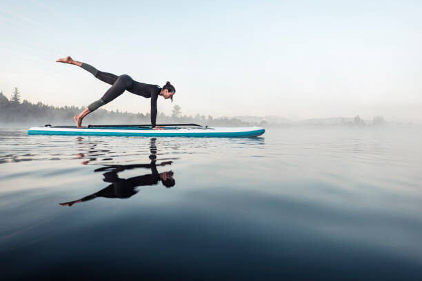Canvas Print Woman practicing paddle board yoga on