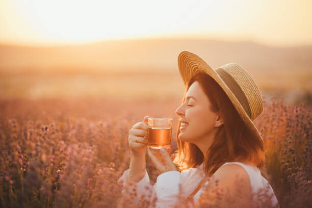 Canvas Print Young happy woman drinking herbal tea,