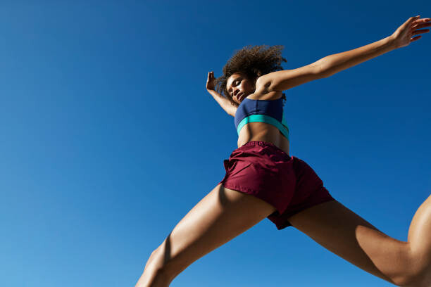 Canvas Print Young woman exercising against clear sky
