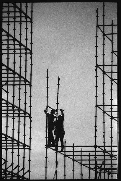 Canvas-taulu Construction Workers Building Scaffolding