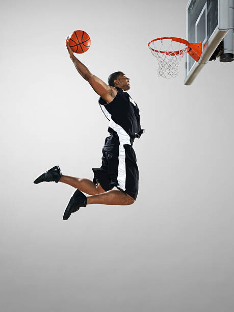 Juliste Basketball player dunking ball, low angle view