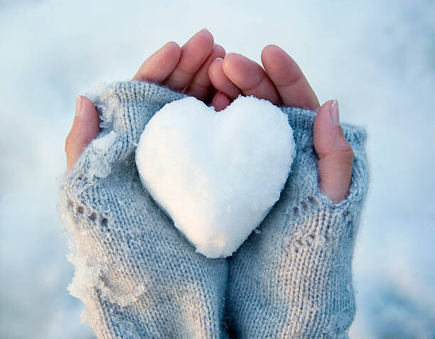 Juliste Woman holding heart-shaped snowball, close-up of