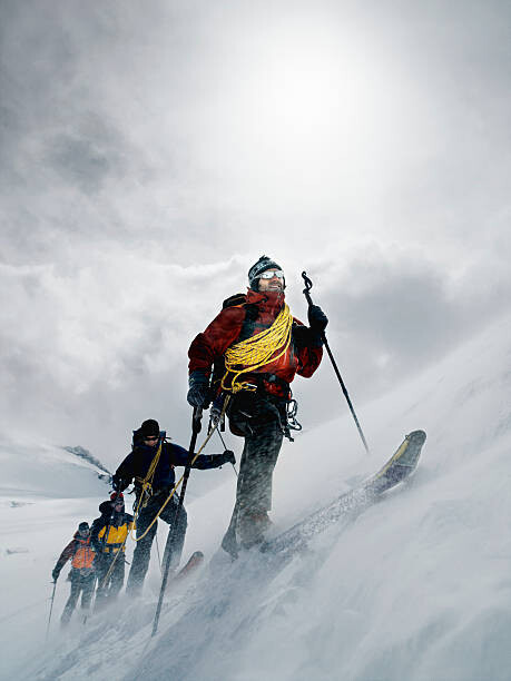 Αυτοκόλλητο Mountain climbers walking through blizzard, linked