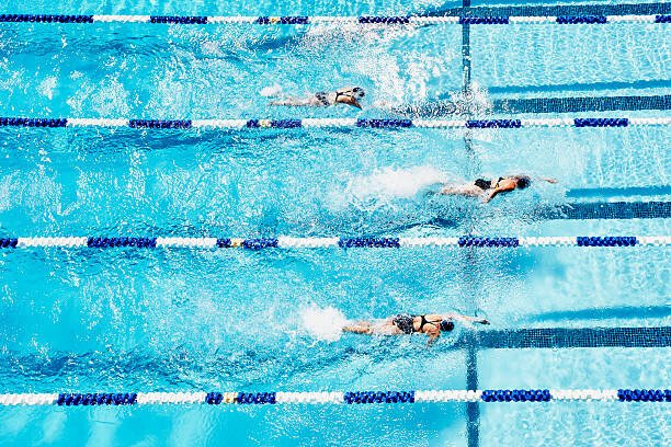 Murais de parede Competitive swimmers racing in outdoor pool
