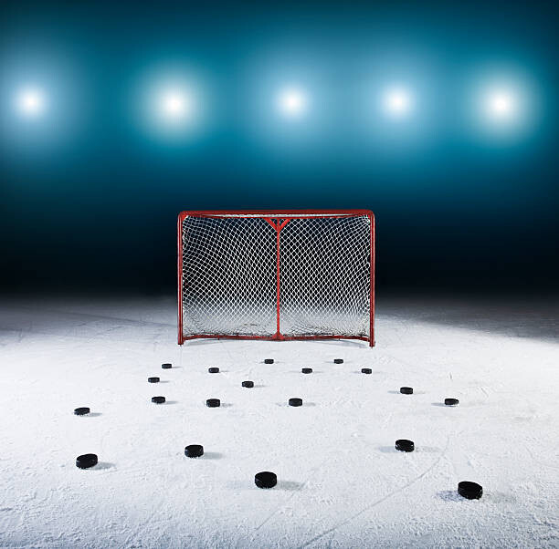 Murais de parede Ice hockey goal surrounded by pucks.