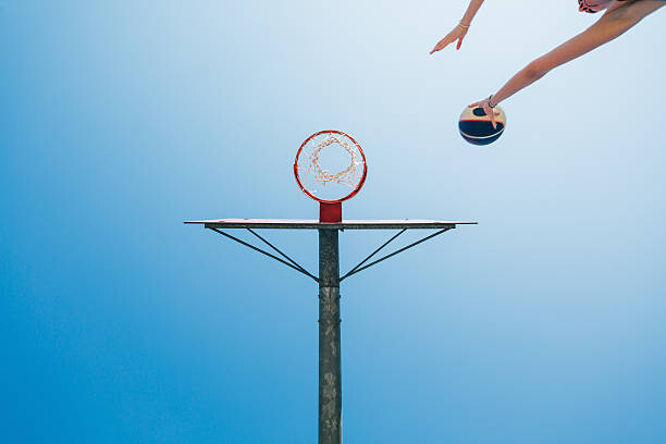 Murais de parede Woman shoots for goal in the basketball court
