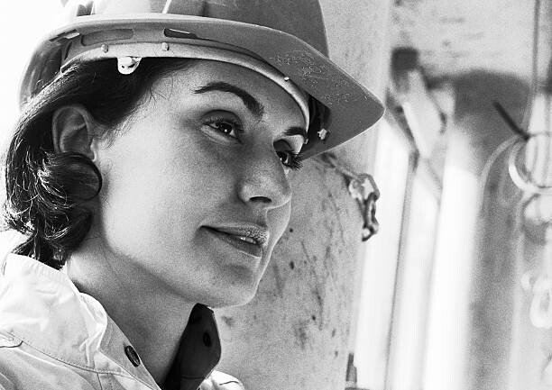 Murais de parede Woman wearing hard hat, close-up, b&w