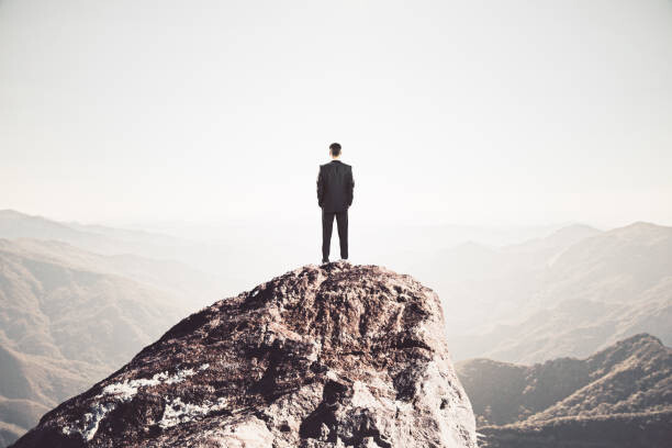 Plakat Businessman standing on mountain