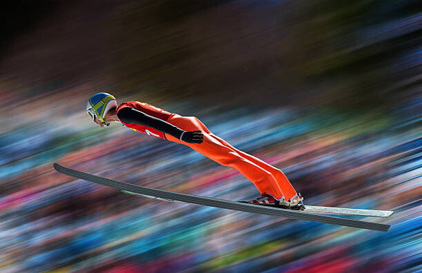 Slika na platnu Ski jumper in mid-air against blurred background