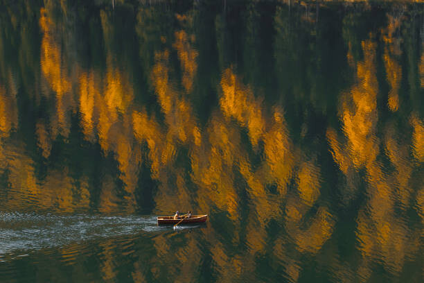 Poster Aerial view of boat sailing by beautiful autumn lake with forest reflection in water