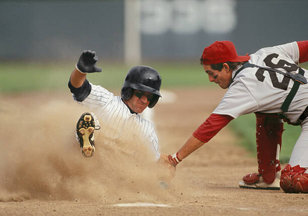 Poster Baseball player sliding into home plate,