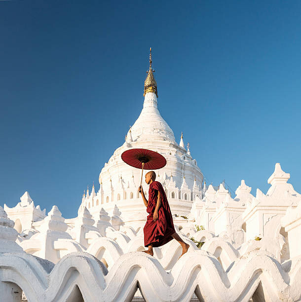 Poster Buddhist monk walking across arches of temple