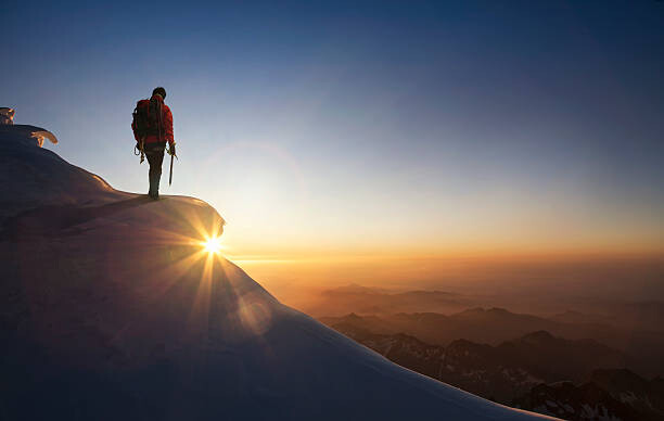 Poster Climber on a snowy range at sunset